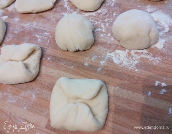 Загните концы вовнутрь, переверните булочки гладкой стороной вниз и сформируйте шарики.