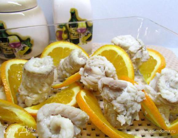 Рулетики из рыбы выложить в форму для заливного, перемежая их ломтиками апельсина.