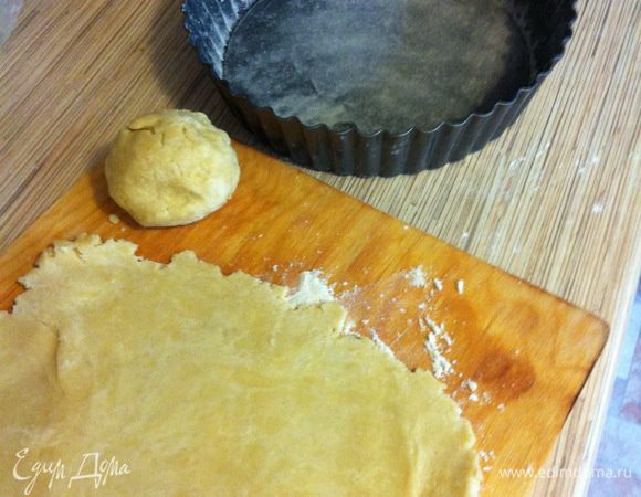 Отдохнувшее тесто разминаем руками, берём от него две трети и раскатываем, выкладываем в форму (форму я смазала небольшим количеством сливочного масла и присыпала мукой, её диаметр = 25 см) и делаем для начала высокие бортики.