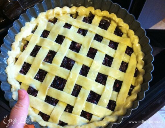Закрываем пирог полосками из теста в решётку, высокие бортики сфорачиваем вниз и подлепливаем. 
Отделяем желток от белка, желток посыпаем солью и сахаром, перемешиваем, добавляем молоко и кисточкой смазываем тесто по всей поверхности. 
В разогретую до 180°C духовку ставим форму с пирогом, выпекаем его при той же температуре 45-50 минут на уровне чуть выше среднего.