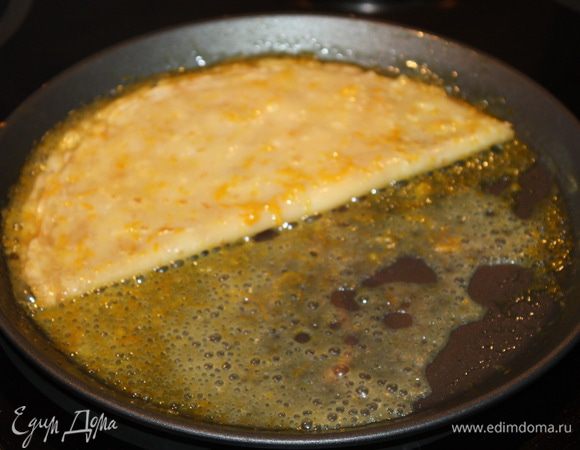 Складываем блин пополам. Затем добавляем коньяк и поджигаем, то есть фламбируем. Как только огонь погас, складываем блин еще раз пополам и выкладываем на блюдо.