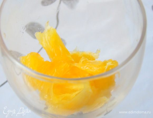 В бокал положить мякоть апельсина мелко измельченную.