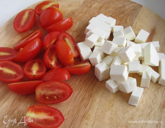 Пока запекается цукини, нарезать черри половинками, фету кубиками. Измельчить мяту и петрушку. Поджарить кедровые орешки.