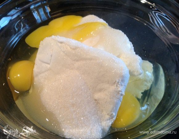 Духовку разогрейте до 200 градусов.  
Творог, яйца и сахар смешайте до однородности, можно с помощью блендера.