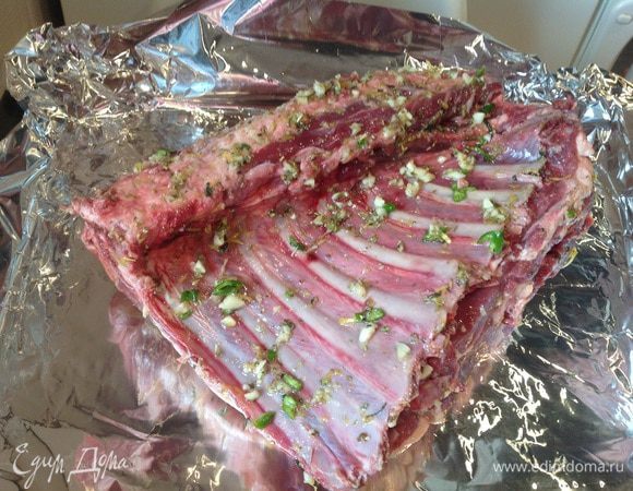 Натрите полученной смесью каре ягненка, выложите на противень застеленный фольгой и поставьте в духовку, готовьте около 2 часов, регулярно поливая выделившимся соком. 
