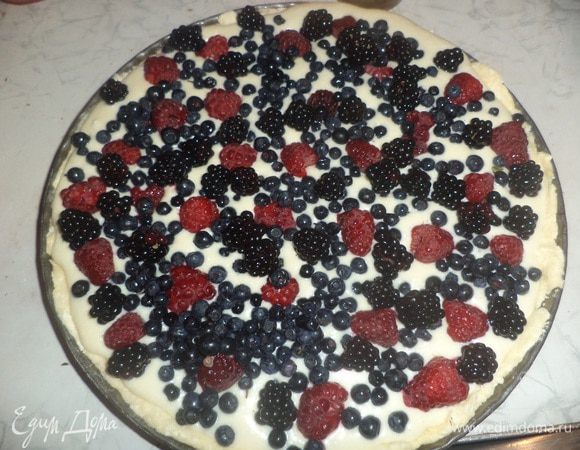 Форму для выпечки смазать маслом, присыпать мукой, выстелить форму тестом, сформировав высокие бортики. Вылить на тесто начинку. А на начинку выложить ягоды. Я использовала малину, ежевику и чернику. Но, конечно, можно попробовать и другие сочетания ягод.