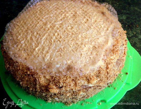 Верх и бока торта так же смазать кремом. Бока торта обсыпать бисквитной крошкой или крошкой из печенья. Чтобы верх торта напоминал соты, сверху приложить кусочек упаковочной пленки с пузырьками, слегка придавить и поставить торт в холодильник на 3 часа и более.