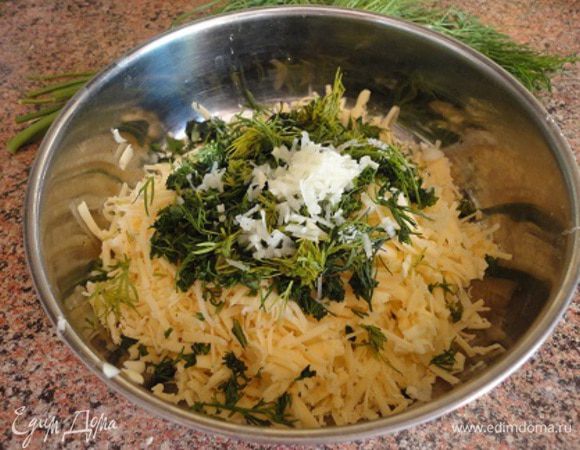 Любой твердый сыр натереть на мелкой терке, холодное сливочное масло — на крупной. Чеснок измельчить, можно тоже натереть. Добавить рубленую зелень.