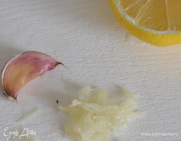 Чеснок натереть на мелкой тёрке, выжать лимонный сок.
