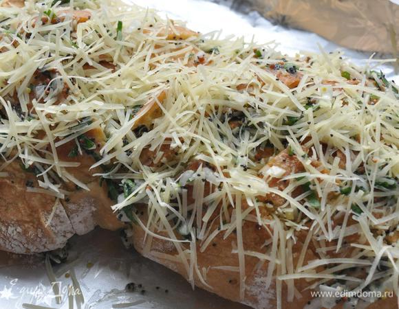 Сыр мелко натереть и разложить в разрезы. Накрыть чабатту фольгой, плотно закрыть. Запекать на решетке гриля 10-12 минут до расплавления сыра. 
