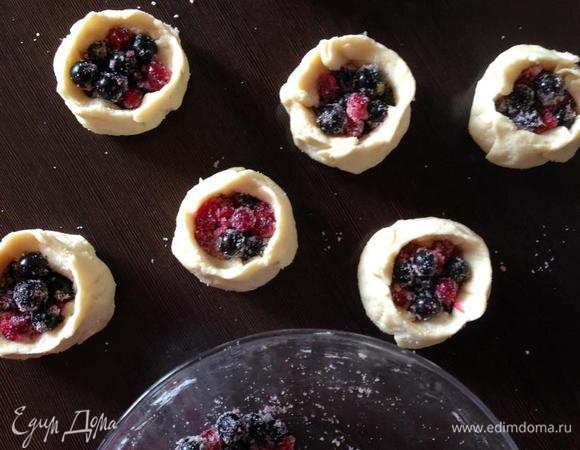  Для начинки смешиваем мытые и процеженные ягоды, сахар и манку.
Заполняем серединку лепешек начинкой (у меня помещалась по 1 ст. л.).  Поправляем тесто вокруг начинки таким образом, чтобы ягоды были ниже краев теста.
