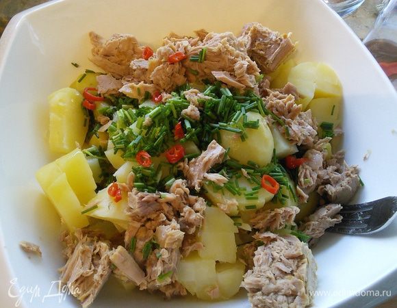 В салатницу выложить очищенный и порезанный картофель, горошек и фасоль, мелко порезанный шнит-лук (можно заменить на репчатый или зелёный) и чили. Из тунца слить жидкость, выложить рыбу к овощам и немного размять вилкой. 