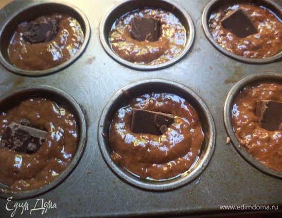 Формы для маффинов на 2/3 заполнить тестом, погрузить в тесто кубики шоколада. Выпекать 30 минут при температуре 180 градусов.