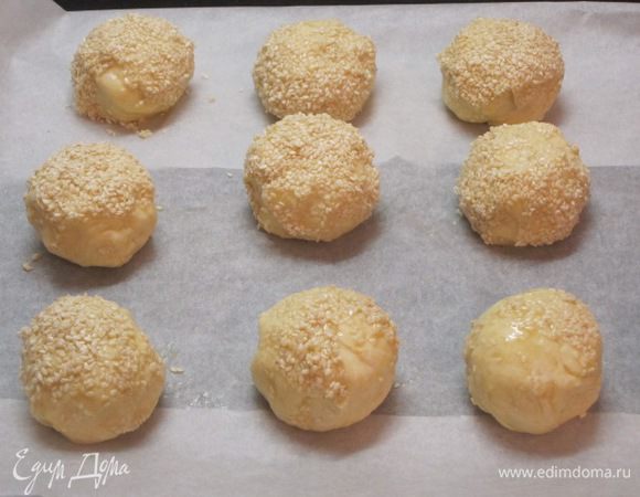 Обмакнуть каждый шарик теста в желток, затем в кунжут. Выложить на противень, выстланный бумагой для выпечки.