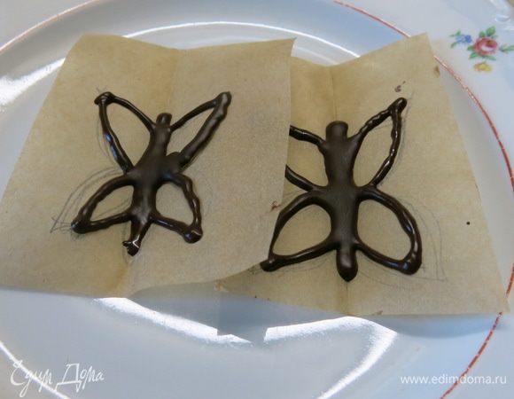 Наполняем мешочек шоколадом и рисуем на пекарской бумаге, с обратной стороны рисунка, бабочек. Слегка сжимаем по намеченному ранее сгибу. Застывать бабочки "летят" в холодильник на 10 минут :)