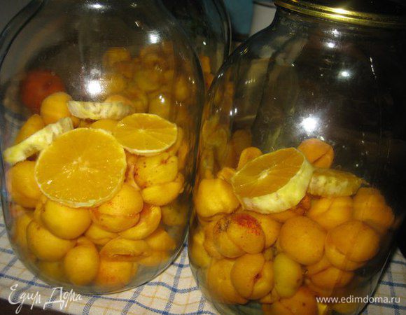 В чистые, сухие и стерилизованные банки складываем абрикосы и апельсины.