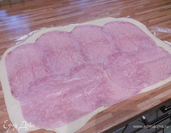 Выложим ветчину тонкой нарезки, отступая приблизительно 2 см от конца теста. 