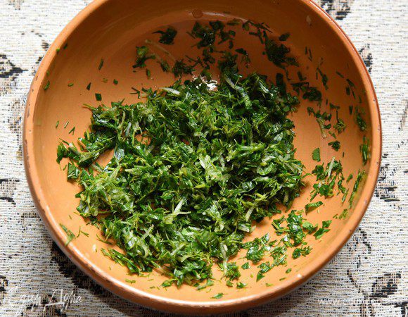 В миску с зеленью добавить измельченный чеснок, соль. Хорошо помять (пестиком или вилкой) так, чтобы зелень дала сок.
