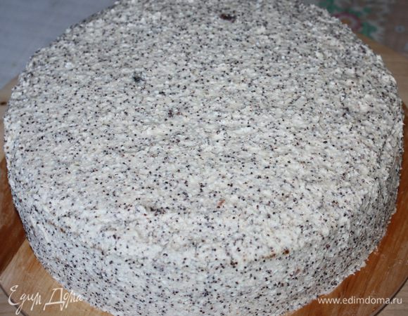 Сборка торта. Корж кладем на ровную поверхность и одеваем кольцо. Я использовала кольцо d=26 см. Пропитываем каждый корж фиалковым сиропом. Первый корж смазываем кремом. Затем второй корж пропитываем сиропом и выкладываем его в форму, закрываем кремом. Выкладываем последний бисквитный корж, смазываем его кремом. Убираем торт на 35-40 минут в морозильную камеру. После этого снимаем кольцо и обрабатываем бока торта. Опять убираем в морозильную камеру минут на 10.