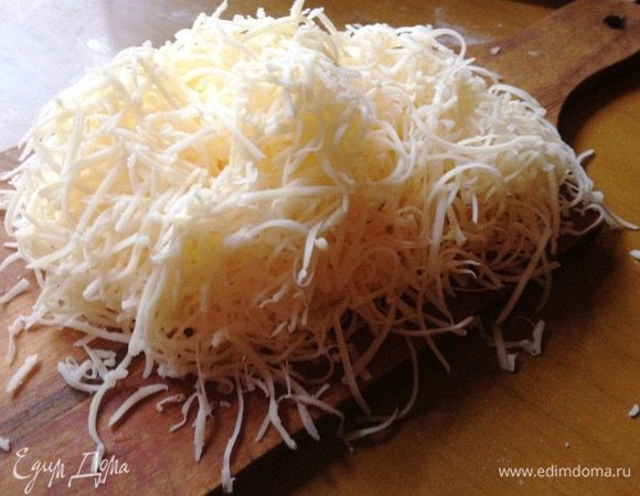 Сыр натереть на тёрке. Вмешать в ризотто, оставив немного для украшения.