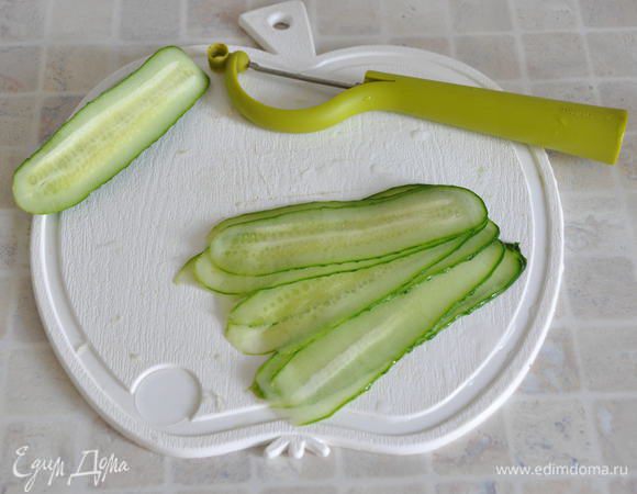 Для подачи: один огурец нарезать слайсами с помощью специальной терки или овощечистки.

