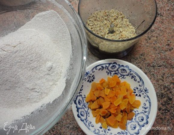 Орехи слегка обжарьте в духовке или на сухой сковороде. Остудите, руками обшелушите кожицу и измельчите. Курагу нарежьте мелкими кусочками. 