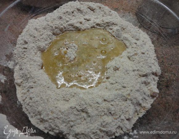 Муку просейте, добавьте размягченное масло, перемешайте, затем добавьте орехи, курагу и пакетик сухих быстродействующих дрожжей. Сделайте воронку в центре и влейте мед (или кленовый сироп) и теплую воду. Воды может понадобиться или чуть больше или чуть меньше. 