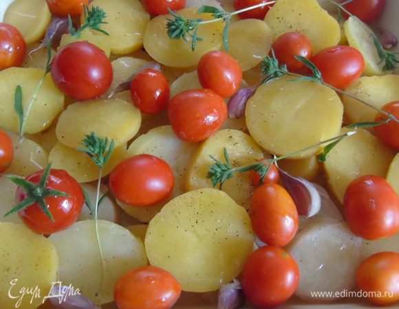 Помидорки чери вымыть и положить поверх картофеля. Добавить веточки  и цветы тимьяна.