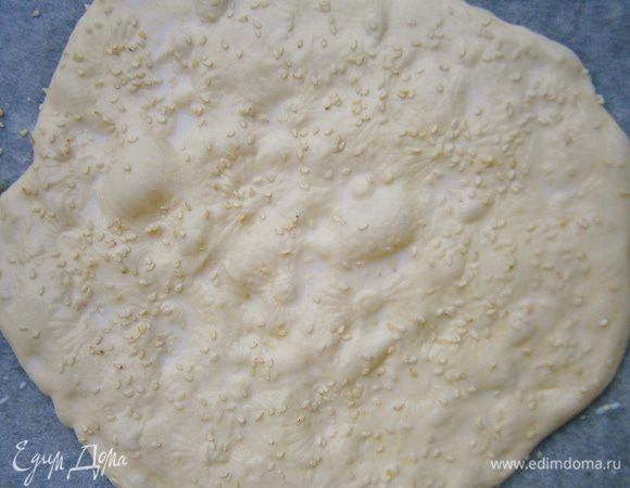 Расстойка под плёнкой 30 минут.
Перед выпечкой я смазала лепешку молоком и посыпала кунжутом, но это не обязательно.