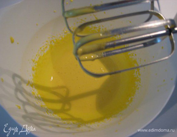Яичные желтки взбить миксером, струйкой влить горячий сахарный сироп, взбить до пены.