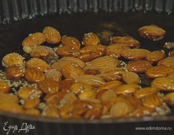 Прогревать орехи в разогретой духовке 10 минут, периодически перемешивая, чтобы они не сгорели.