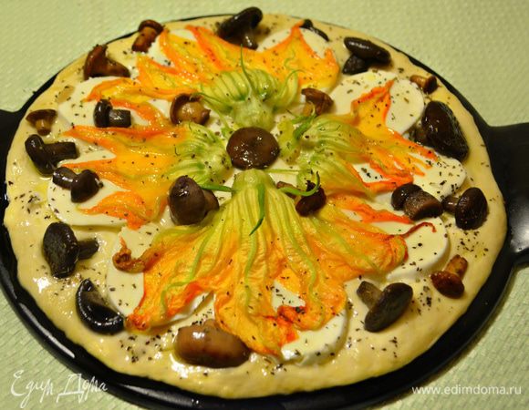 Выложить цветы цукини поверх моцареллы, аккуратно расправляя лепестки, и равномерно разложить по всей поверхности грибы. Приправить сухим базиликом, сбрызнуть оливковым маслом и поставить в разогретую духовку на 25-30 минут.