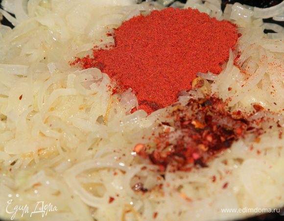 Лук нарезаем полукольцами и отправляем пассероваться туда, где до этого были колбаски. Готовим до того момента как лук "обмякнет". Добавляем паприку и красный острый перец, перемешиваем, добавляем немного воды и протушиваем пару минут. 