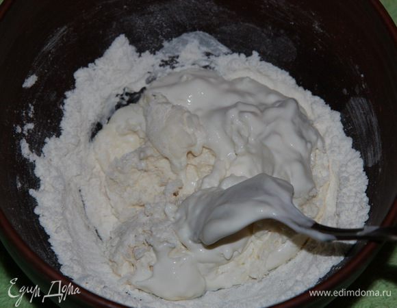 Затем к муке порциями подмешиваем сметану так, чтобы не образовывались комочки. Если сметана сильно густая можно добавлять водичку.