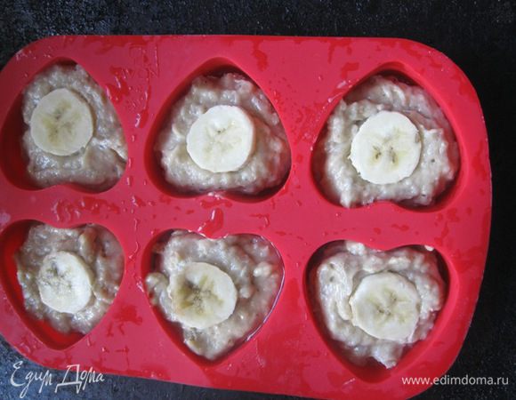 Формочки смазать маслом. 
Выложить тесто в формы, заполнив их на 3/4. Сверху выложить кружочек банана. Выпекать в разогретой (180 С) духовке, минут 22-25. Ориентируйтесь по вашей духовке.