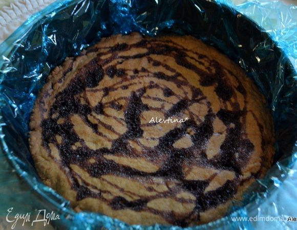 Используем съемную форму для сборки торта. Выложить пищевую пленку так чтоб концы свисали. Если нужно делайте два слоя внахлест. Затем слой охлажденного готового печенья.