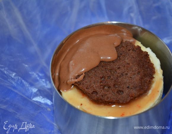 Далее накрываем снова слоем "Джаконда", поливаем сиропом и готовим шоколадный мусс.

Для этого:
Варим сироп из воды и сахара до 118 градусов. Снимаем с огня и вводим желтки, ставим на паровую баню. Варим до загустения. Снимаем, немного охлаждаем и вводит за ранее замоченный желатин. Остужаем. Тем временем взбиваем сливки и добавляем к ним растопленный шоколад. Перемешиваем лопаткой обе массы. Крем готов. Форму от торта разжимаем, получаются зазору. И в них вливаем мусс. Фото на примере пирожного, которое я готовила параллельно. Я взяла кольцо большего диаметра.