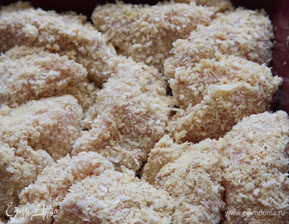 Затем обваливаем кусочки филе в сухарях и укладываем в емкость для запекания.