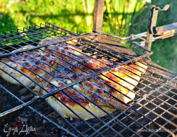 Выложите курицу на решетку, поместите над горячими углями и быстро обжарьте до румяной корочки с обеих сторон. Затем раздвиньте угли в разные стороны и поместите решетку между ними. Доведите курицу до готовности (около 20 минут), периодически переворачивая.
