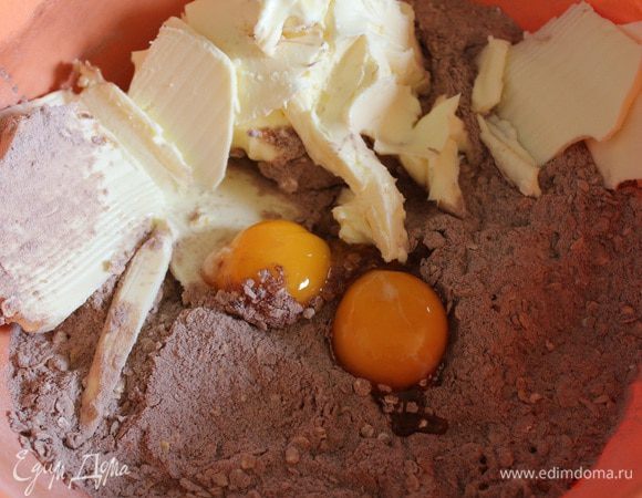 Затем добавить масло комнатной температуры и желтки, хорошо перемешать. Должно получиться рассыпчатое тесто.