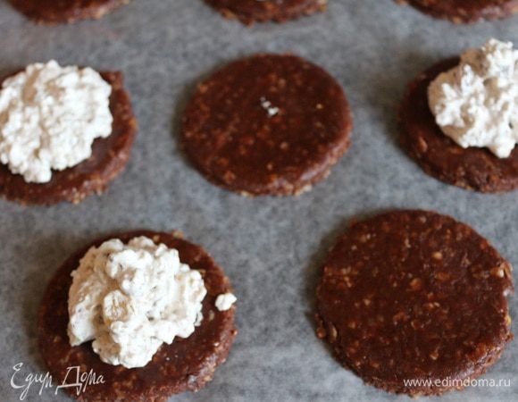 Смазать стол растительным маслом, раскатать тесто до толщины примерно 3-4 мм, вырезать кружочки. Выложить кружочки на противень, застеленный пекарской бумагой, смазанной сливочным маслом. Выложить ложкой на половину кружков в середину начинку.