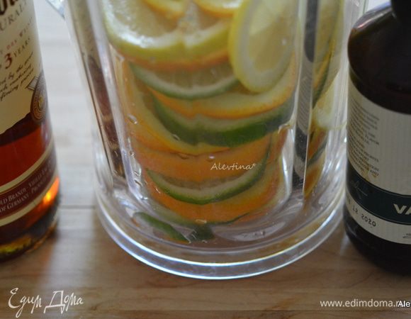 Заполнить кувшин цитрусами, залить белым вином, бренди, ванильным экстрактом. Поставить в холодильник на 2 часа.