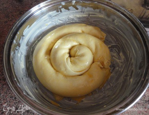 Противень или любую удобную форму для запекания смажьте сливочным маслом и уложите рулеты спиралью. Смажьте сверху желтком.