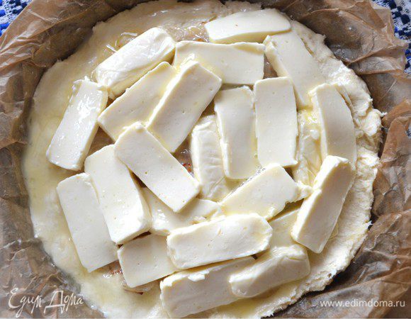 Порезать плавленный сыр кусочками и разложить на лук. в чашке взбить вилкой яйцо и смазать им начинку, равномерно.