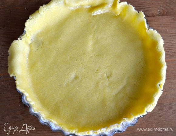 Тесто достать из холодильника. 2/3 от теста раскатать в пласт толщиной примерно 5-7 мм, перенести и выложить в подготовленную форму. Для удобства тесто можно раскатать на листе пекарской бумаги и затем вместе с этим листом перенести его в форму.