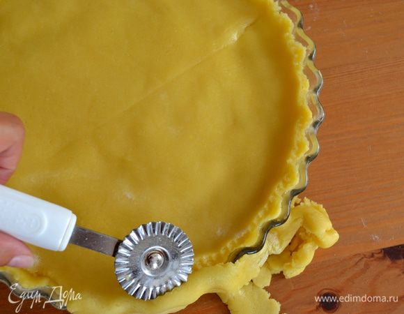 Оставшееся тесто также раскатать и выложить сверху, позволяя полностью накрыть крем. Края аккуратно скрепить и обрезать излишки теста.