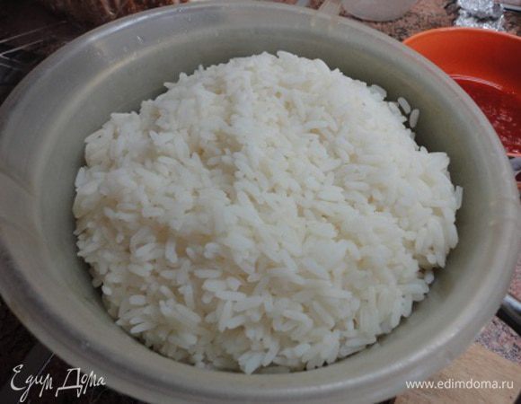 К этому времени готовый рис откинуть на дуршлаг, дать стечь воде и выложить его в сковороду.
