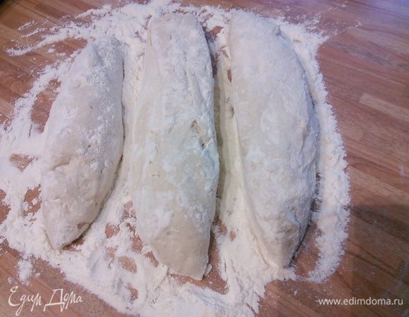 По прошествии двух суток на посыпанной мукой поверхности  разделите тесто на 3 части, сформируйте цилиндры, дайте 15 минут отдохнуть под плёнкой. 