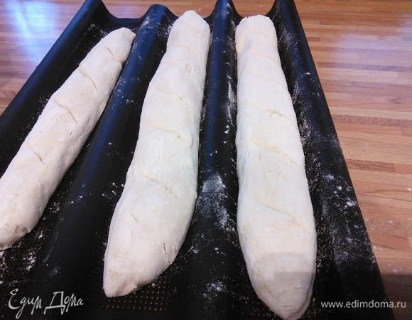 Сформируйте багеты, переложите на противень, покрытый пекарской бумагой,  сделайте надрезы лезвием или острым ножом 