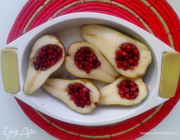 Выложить половинки груш в форму, в углубление положить свежую бруснику  и сверху посыпать ванилью и сахарной пудрой.
Накрыть форму фольгой и запекать в духовке до мягкости 30–40 минут. 
